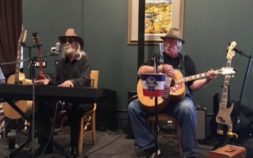 Old Friends members practicing inside of a room. Pictured with their instruments.