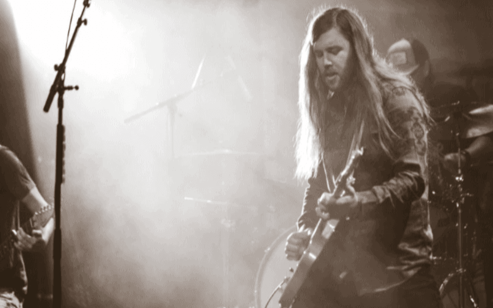 Slade Coulter group pictured in a black and white picture while performing on stage.